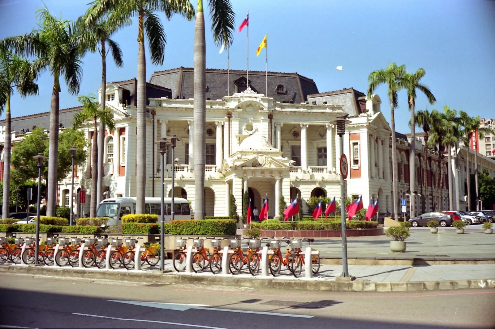 臺中州廳白色巴洛克式正立面,前方一排 iBike 與國旗,2026 創意台中展場
