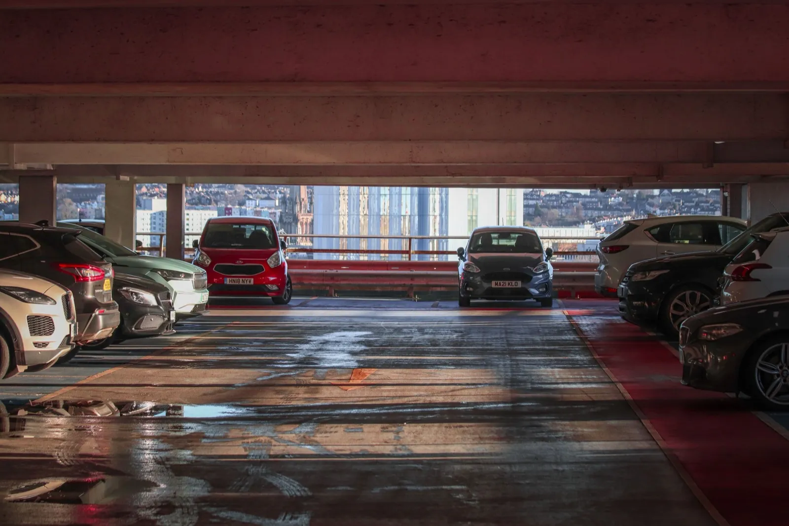 立體停車場樓層裡停滿的車輛,外側可以看到城市街景,國慶連假台中停車