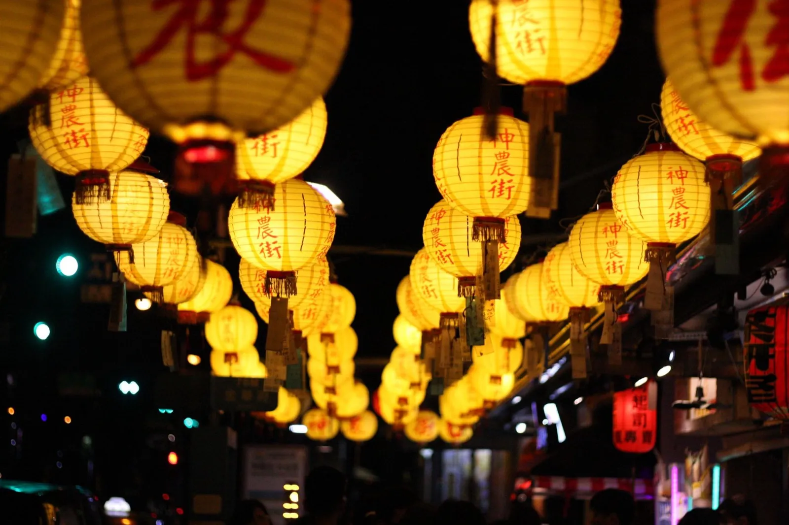 夜裡一整排黃色紙燈籠掛在老街上空,燈籠上寫著紅字,鈴蘭通散步納涼會中山路封街