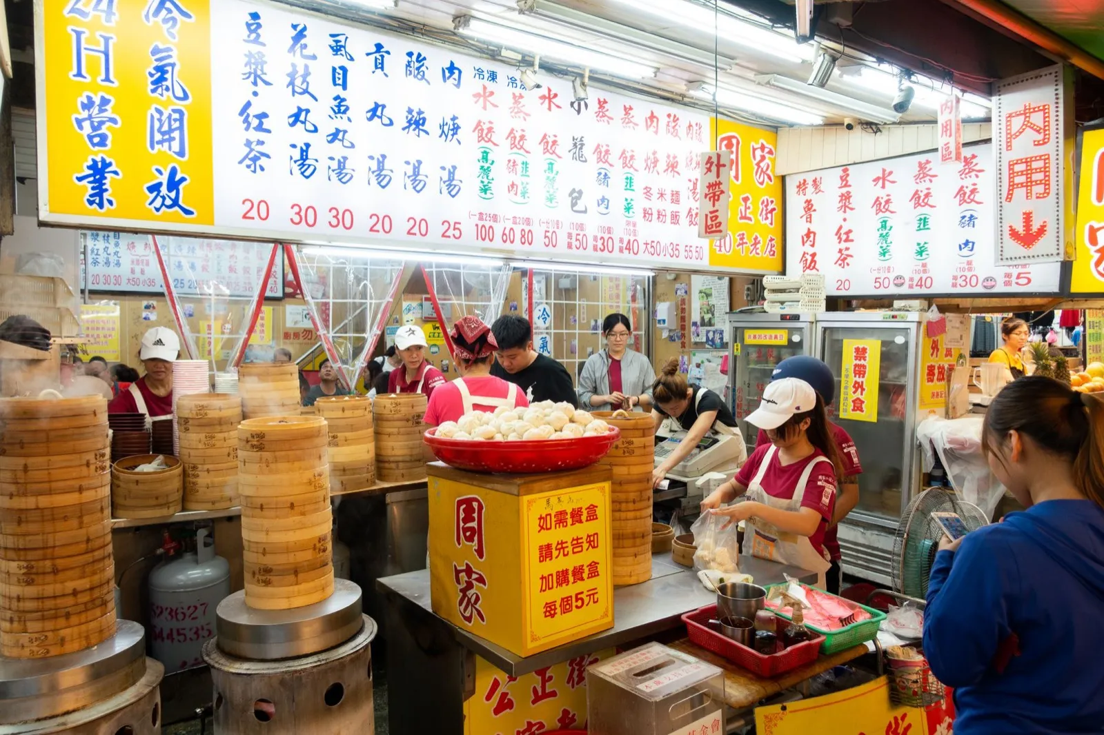 台灣夜市小吃攤的蒸籠與包子，店員正在打包，松竹站食駅散策市集